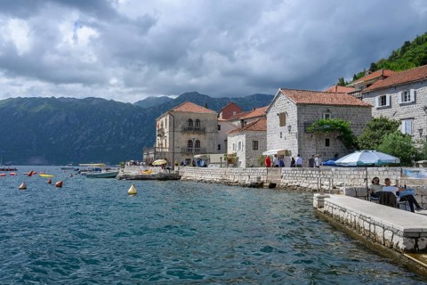 Tourists stroll along the waterfront at Boka Kotor bay (Boka Kotorska), Perast, Montenegro