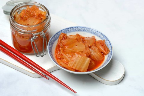 Kimchi, fermented vegetables in glass container and bowl