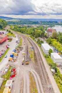 Aerial view of railways and landscape with river, buildings and cloudy sky, Leonhard Weiß