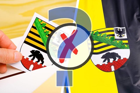 Hand throws the coat of arms of the German federal state of Saxony-Anhalt into a voting box and