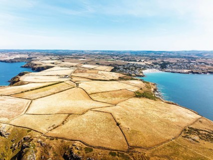 Seven Souls Rock and Pentire Point and Bay over Padstow Bay from a drone, Polzeath, Cornwall,