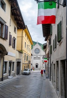 Street with Italian flags, Duomo di Santa Maria Assunta church in the back, Gemona del Friuli,