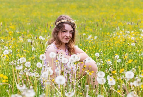 Portrait of a smiling girl sitting in a flower meadow, Mondsee, Salzkammergut, Austria