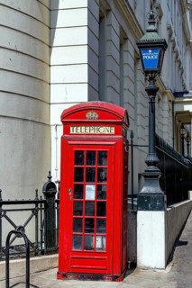 A red K2 telephone kiosk designed by Giles Gilbert Scott in 1927 stands beside a Metropolitan