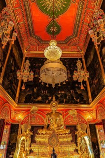 Beautifully furnished temple room with golden Buddha statue, sparkling chandeliers and