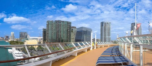 Panoramic view from a cruise ship deck in Tampa, Florida, USA. Sun loungers, glass railing, and