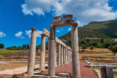 Ancient column formations along a stone path under blue sky, ancient site, archaeological site,