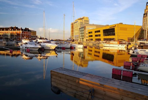Sunset light illuminates yachts and modern buildings in harbor, University, Kalmar, Kalmar Län,