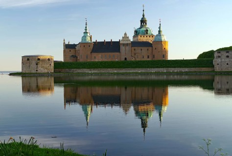 A historic castle and its reflection in a calm lake under a clear blue sky, Kalmar Slott, Kalmar,