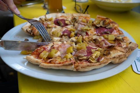 Pizza serving salami and mushrooms in a garden restaurant, Franconia, Bavaria, Germany