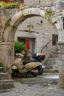 E-fun Pusa electric scooters in an arched entryway, Trogir, Croatia