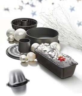 Various baking pans, asterisks and Christmas balls as decoration, against a white background,