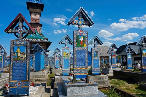 Colourful traditionally designed tombstones in sunny weather in a Romanian cemetery, traditional