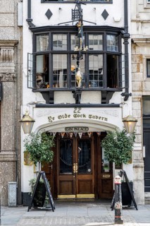 The timber and gilt entrance of Ye Olde Cock Tavern welcomes visitors at 22 Fleet Street, a Grade
