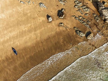 Top Down view fo woman with kayak over Beach from a drone, North Devon and Cornwall Coastpath