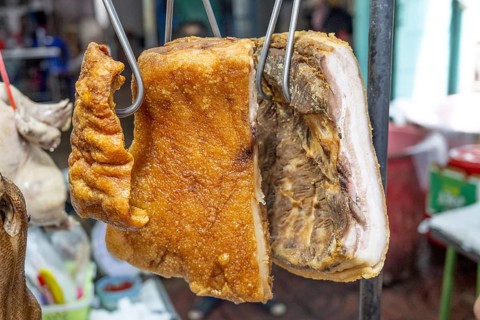 Detail of crispy pork belly known as Mu Krob in Thai, a golden, bubbly crackling on the top with