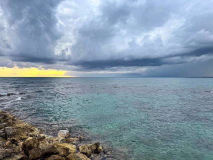 Dark clouds announce a storm over the turquoise sea at sunset, Side, Manavgat, Antalya Province,