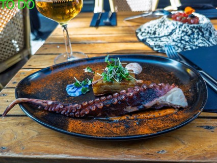 Seville, Spain - Mar 18, 2026: Grilled octopus tentacle seafood dish with layered potato, served as