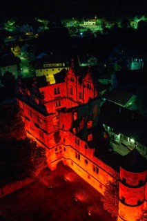 Historic building bathed in red light at night, atmospherically illuminated in the midst of an
