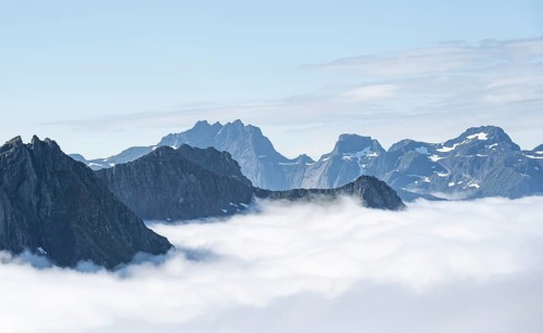 Mountain peaks above the clouds, mountain landscape and sea, view from the summit of
