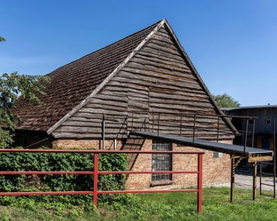 Old barn with brick masonry and traditional wood paneling with tile-covered gable roof, Uckermark,