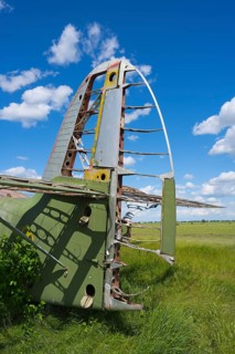 Airplane fin and metal structure in a field under clear blue sky, Antonov An-2 multi-purpose