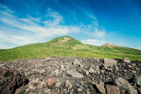 View of a hill surrounded by vegetation against a beautiful blue sky, a beautiful,