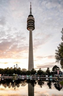 Olympic tower in front of Olympic Lake in the evening during the Superbloom Festival in Munich's