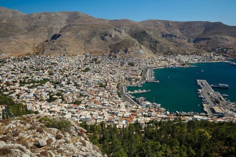 Coastal town with densely packed houses and harbor, surrounded by mountains, Pothia, main town,