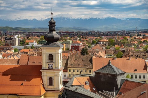 Old town, Catholic parish church of the Holy Trinity and the snow-capped mountains of the