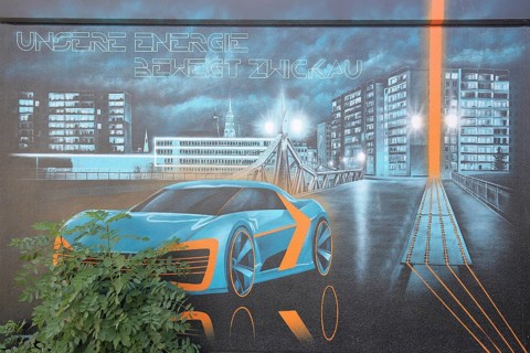 Transformer house with mural inscription our energy moves Zwickau, modern car with cityscape and