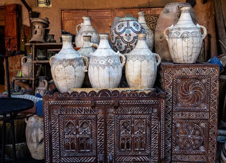 Ancient everyday objects, painted clay jugs, carved decorated wooden doors on display for sale,