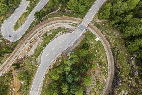 Red train of the Rhaetian railroad line, Bernina Express, 180 degree turn at the Montebello curve,
