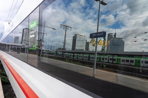 ICE long-distance train in Essen main station, downtown skyline, high-rise office buildings, North
