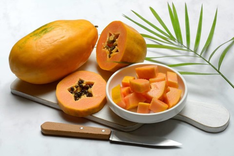 Pawpaw, split fruit in skin, halved and whole fruit, Carica papaya