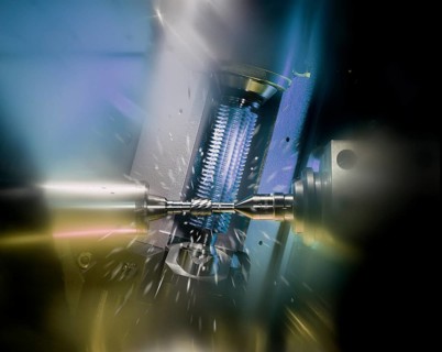 CNC controlled gear hobbing machine precisely machining a metal gear with cutting tool, flying