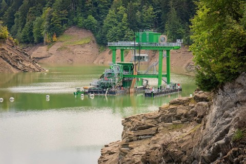 Technical structure on a reservoir surrounded by rocks and wooded hills, Krumbach, Vorarlberg,