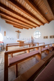 Chapel with wooden benches and rustic wooden ceiling, central altar and round window, Bruder Klaus