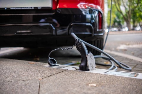 An e-car is charged with a cable at a charging curb on the KÖ, Düsseldorf, Germany