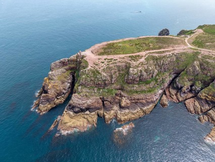 Aerial view of the rocky cliffs at Cap Fréhel with the historic Vauban lighthouse, 17th century