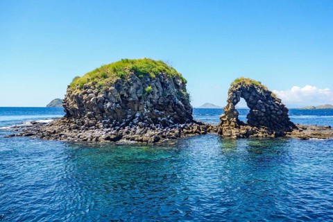 Distinctive rock formation at Batu Bolong dive site means rock with a hole, tourist attraction