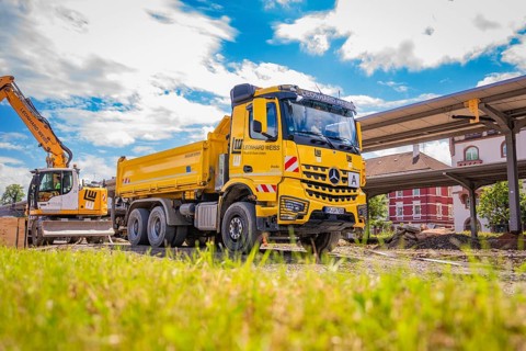 Construction site situation with truck and excavator, blue sky over work, station conversion
