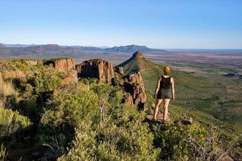 Young woman looking at the Valley of Desolation, eroded rock needles from Dolorit, Camdeboo