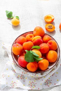 Fresh apricots in a bowl, on a bright table, natural light, top view, no people