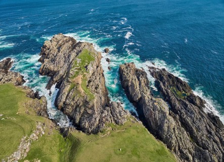 Aerial drone photo of rocky cliffs and heavy atlantic ocean surf, Strathy point, northern Scotland,