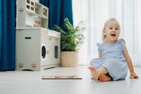 Child girl toddler enjoys a colorful puzzle on the floor while surrounded by soft light and