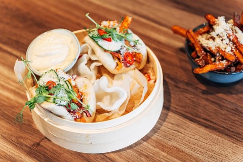 Asian Bao Buns with Fresh Herbs and Crunchy Toppings in a Bamboo Steamer with Sauce