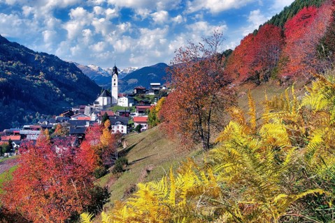 Village view of Sumvitg, autumn-coloured deciduous trees, Vorderrheintal Surselva, Canton of
