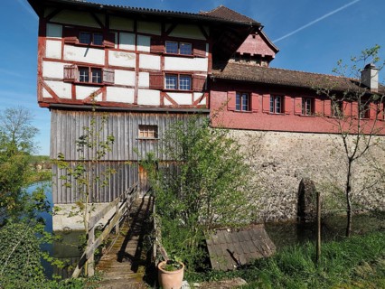 Medieval castle with half-timbered structure with red and white structure, small wooden bridge and