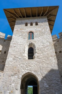 Close-up of medieval tower with stone walls and arched windows under blue sky, Soroca Fortress,